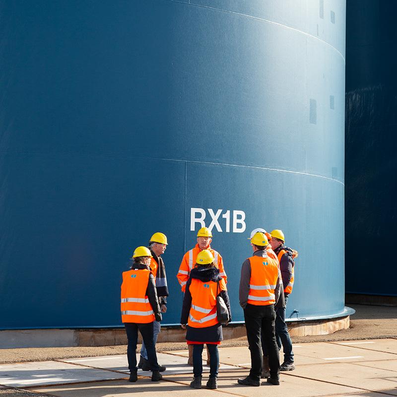 De stakeholders van Pilot Harlingen krijgen een rondleiding bij Frisia zout en overleggen voor een enorme blauwe container.